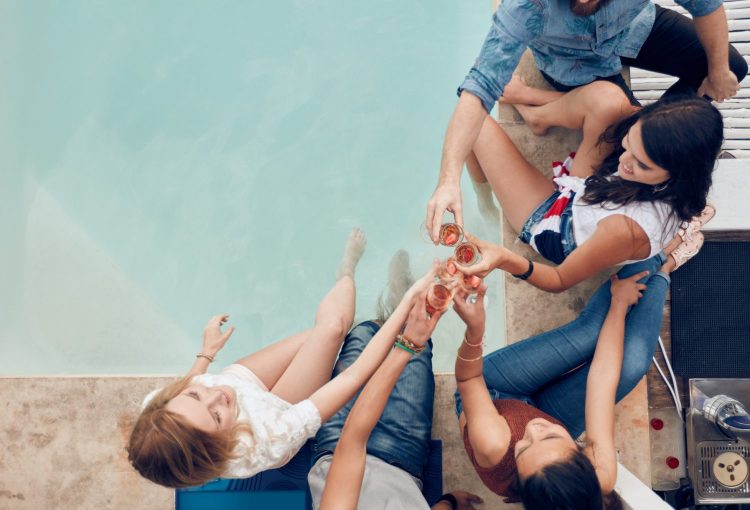 Group of friends toasting at poolside party